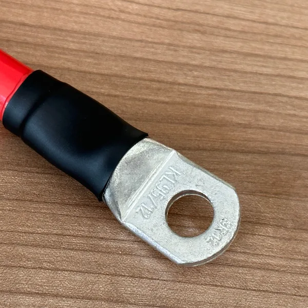 Rohrkabelschuh mit der Prägung KL 95/12 an einem roten Batteriekabel 95mm², Schrumpfschlauch über der Pressstelle
