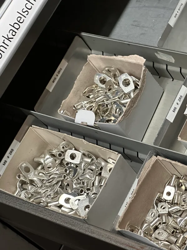 Open drawers of a workshop cabinet filled with ring terminals, the
         compartments labelled by bolt hole