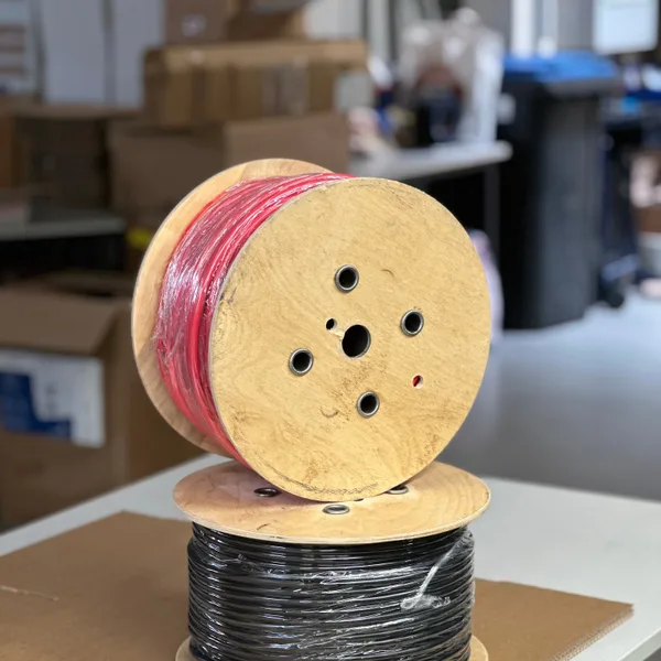 Holztrommel mit schwarzer Fahrzeugleitung auf einem Tisch im Lager